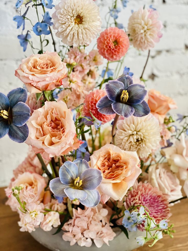 a vase filled with lots of different colored flowers