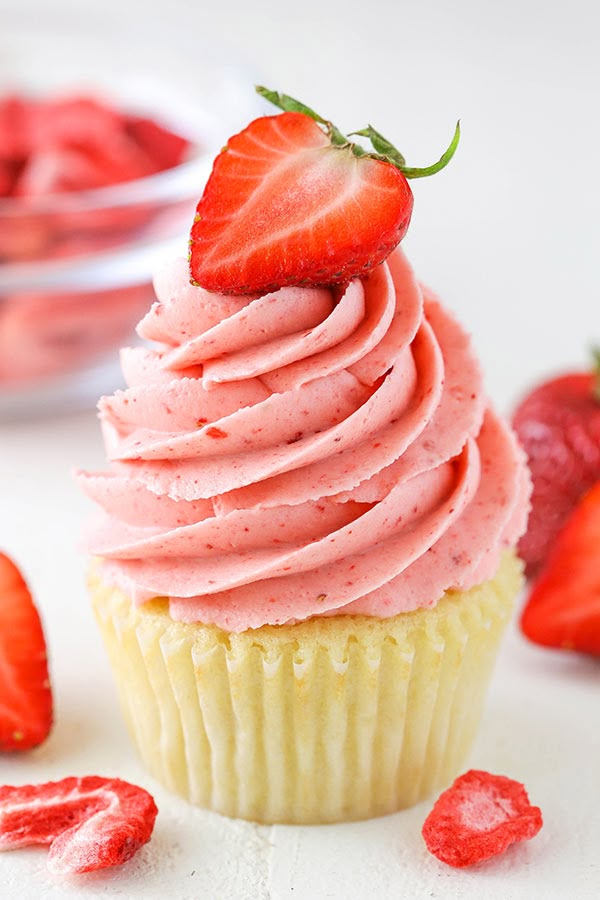 a cupcake with pink frosting and strawberries