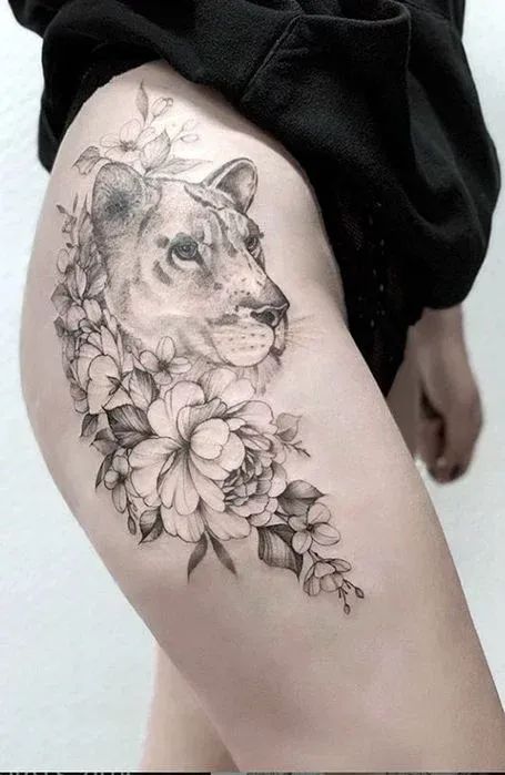 a woman's thigh with a lion and flowers on it