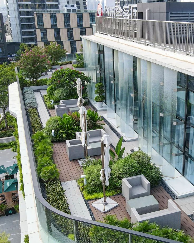 an aerial view of a rooftop garden with benches and umbrellas