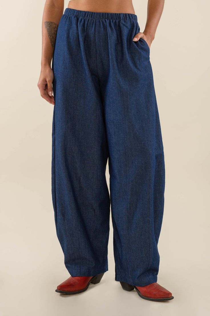 A longer and wider version of our Denim Lantern Pant - Denim wide leg lantern pant with elastic waistband, side pocket, and art detail at hem. High-waisted fit Side pockets  Locally sourced Washed Lightweight Denim Cut and sewn ethically, in-house at our factory in DTLA  Fit  Model is 5'7" and wearing size S View ful Wide Leg Denim Harem Pants With Pockets, Baggy Denim Blue Bottoms With Elastic Waistband, Baggy Denim Harem Pants, Baggy Jeans With Elastic Waistband, Dark Wash Relaxed Fit Wide Leg Pants, Relaxed Fit Dark Wash Wide Leg Pants, Baggy Wide Leg Harem Pants With Pull-on Style, Denim Blue Cotton Wide Leg Harem Pants, Denim Blue Wide Leg Cotton Harem Pants