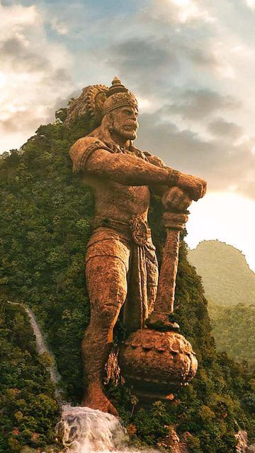 a statue is standing on top of a rock in the middle of a jungle area