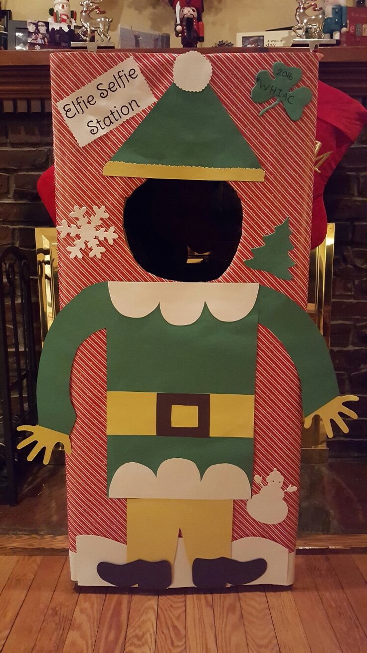 a cardboard elf costume sitting on top of a wooden floor