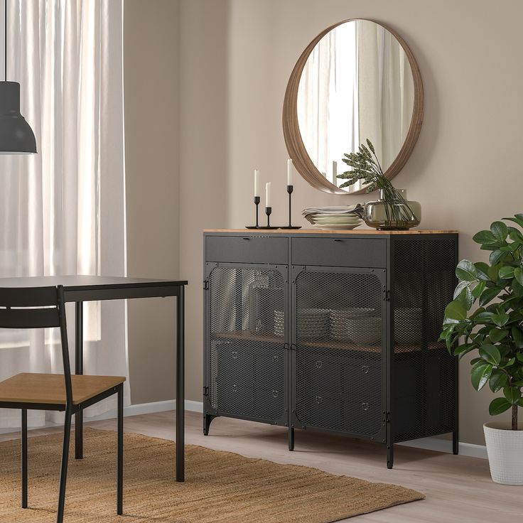 a room with a table, chair and mirror in it next to a potted plant