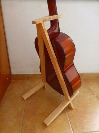 a guitar stand made out of wood on the floor