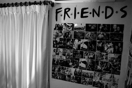 a wall covered in pictures and the word friends written on it is next to a window