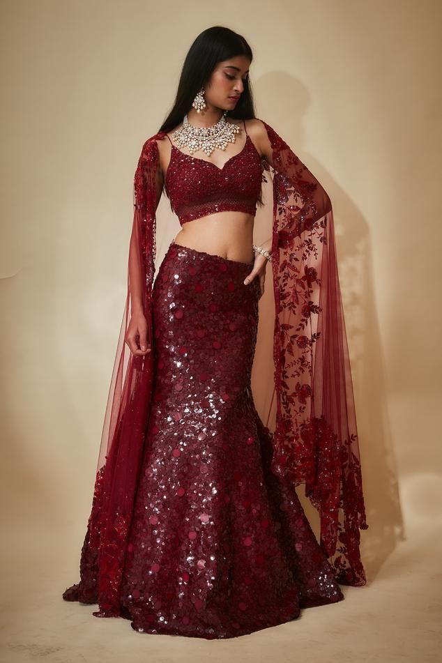 Burgundy mermaid lehenga with an attached cancan and sequins hand embroidery. Comes with a padded blouse and a floral work dupatta. Components: 3 Pattern: Hand embroidered Type Of Work: Sequins, Floral Neckline: Leaf Neck Sleeve Type: Sleeveless Fabric: Tulle, Sequins georgette, Buttercrepe Color: Maroon Other Details:  Heavily embroidered blouse Lehenga length : 45 inches Occasion: Destination Wedding - Aza Fashions Luxury Lace Lehenga With Traditional Drape, Luxury Red Lehenga With Sheer Dupatta, Luxury Red Lehenga With Unstitched Blouse, Luxury Formal Lehenga With Cutdana, Luxury Net Lehenga For Festive Occasions, Luxury Red Draped Lehenga, Luxury Red Unstitched Lehenga, Luxury Elegant Lehenga With Fitted Bodice, Luxury Sequined Lehenga For Gala Events