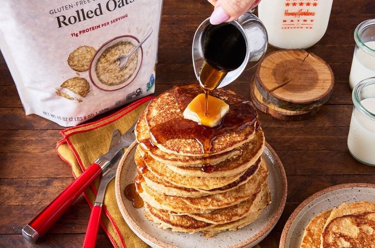 a stack of pancakes with syrup being poured on top