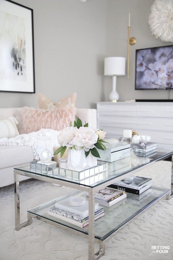 a glass coffee table with flowers on top