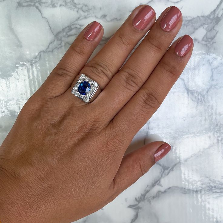 a woman's hand with a ring on it and a blue stone in the middle