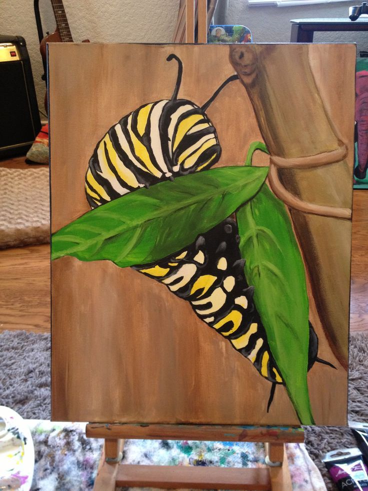 a painting of two butterflies sitting on top of a green leafy plant next to a wooden easel