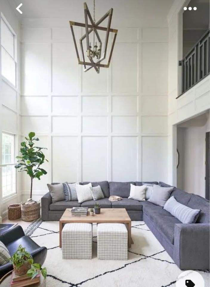 a living room filled with furniture and a chandelier hanging over the top of it