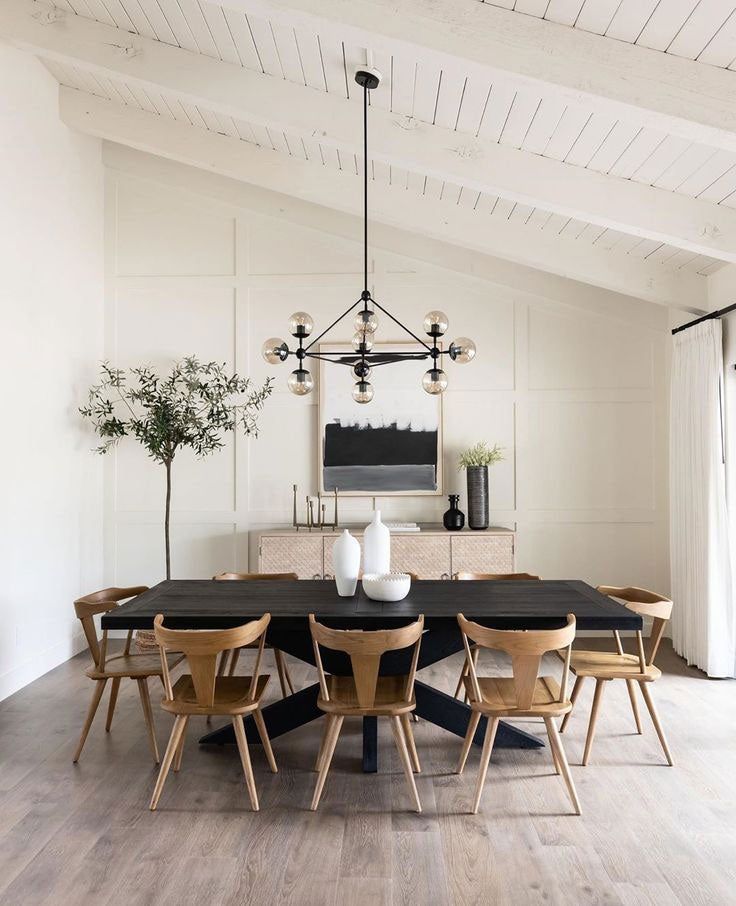 a dining room table with chairs and a vase on it