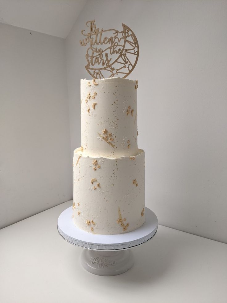 a three tiered cake with gold stars on it