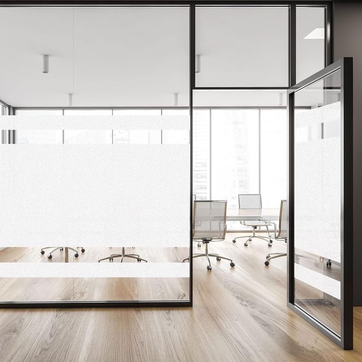 an office with glass walls and wooden floors