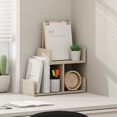 a desk with a clock, cactus and other office supplies