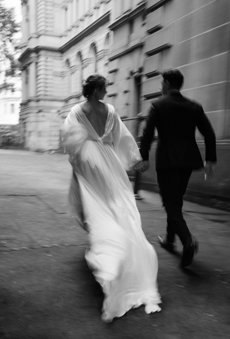 black and white photograph of two people walking down the street