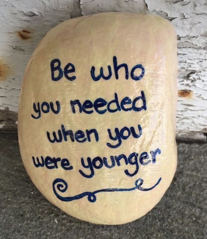 a rock with the words be who you needed when you were younger