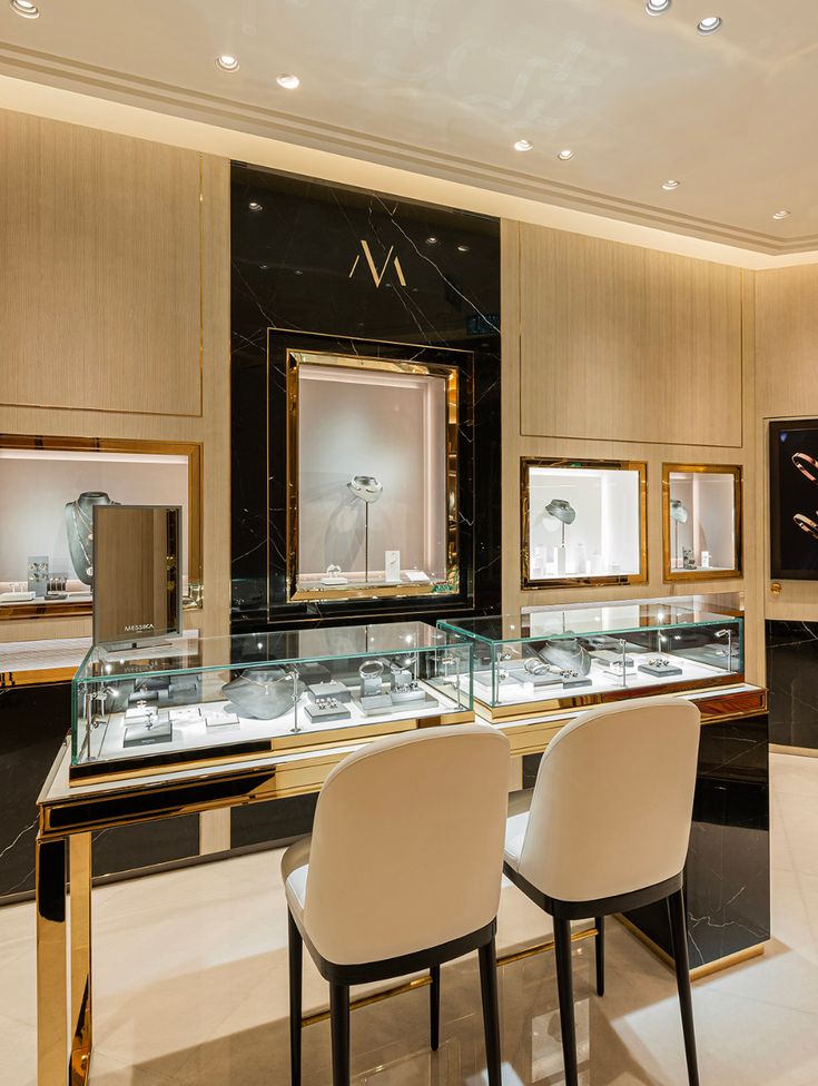 the interior of a jewelry store with chairs and mirrors on the wall, along with other items