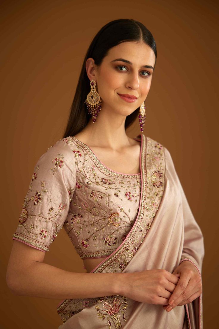 Editor's Note This ensemble features a beautiful whisper pink sari made of dupion silk, with intricate zardozi embroidery work on the borders. The matching blouse is also embellished with the same embroidery work, adding to the overall elegance of the outfit. Color: Pink Fabric: Dupion silk Embroidery details: Zardozi embroidery Components: Sari & blouse Sari length: 6 meters, sari width: 46" inches Occasion: Engagement and wedding guest Disclaimer: Product color may slightly vary due to photogr Pink Art Silk Pre-draped Saree With Intricate Embroidery, Raw Silk Pre-draped Saree With Resham Embroidery, Pink Raw Silk Pre-draped Saree With Resham Embroidery, Chinon Pre-draped Saree For Reception In Transitional Season, Chinon Pre-draped Saree For Reception And Transitional Season, Festive Pink Pre-draped Saree With Dori Work, Transitional Reception Pre-draped Chinon Saree, Pink Chinon Pre-draped Saree For Navratri, Pink Anarkali Style Silk Pre-draped Saree