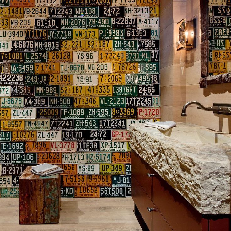 a bathroom with a sink, mirror and large number tiles on the wall