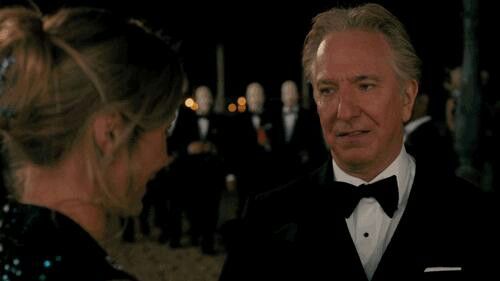 an older man in a tuxedo talking to a woman