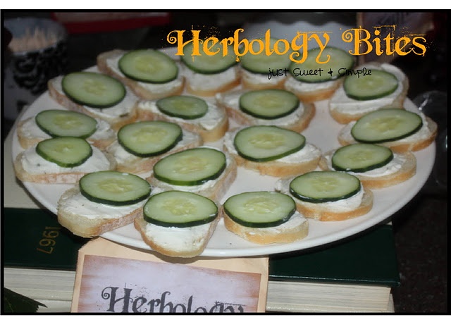 cucumber sandwiches are arranged on a plate next to a sign that reads herbology bites