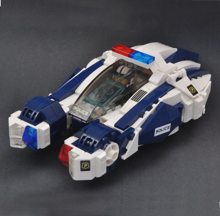 a lego police car with money in it's back end, on a gray surface