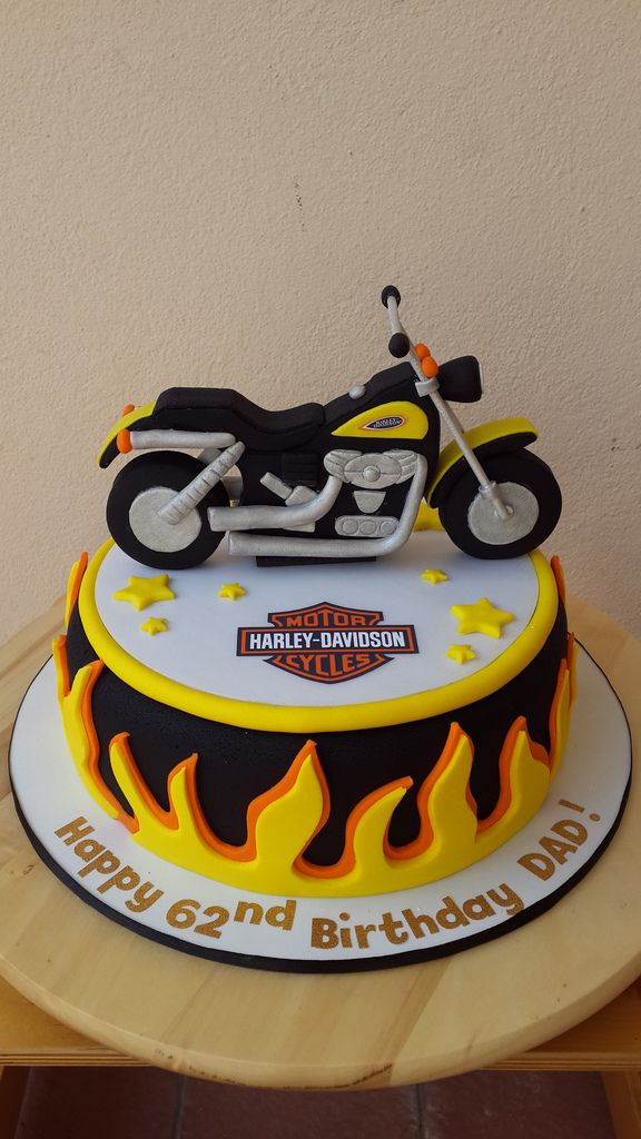 a birthday cake with a motorcycle and flames on the top is ready to be eaten