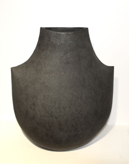 a black vase sitting on top of a white table