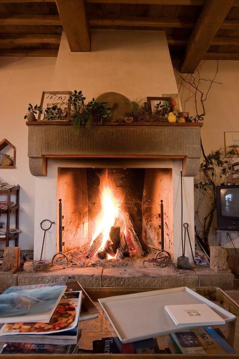 a living room with a fire place in the middle and pictures on the fireplace mantle