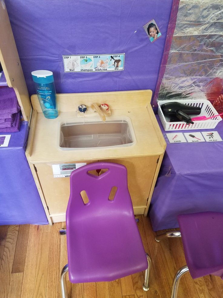 a purple desk and chair with a sink in the middle next to some other items