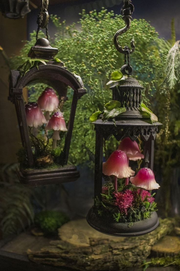 two hanging lanterns filled with flowers and plants