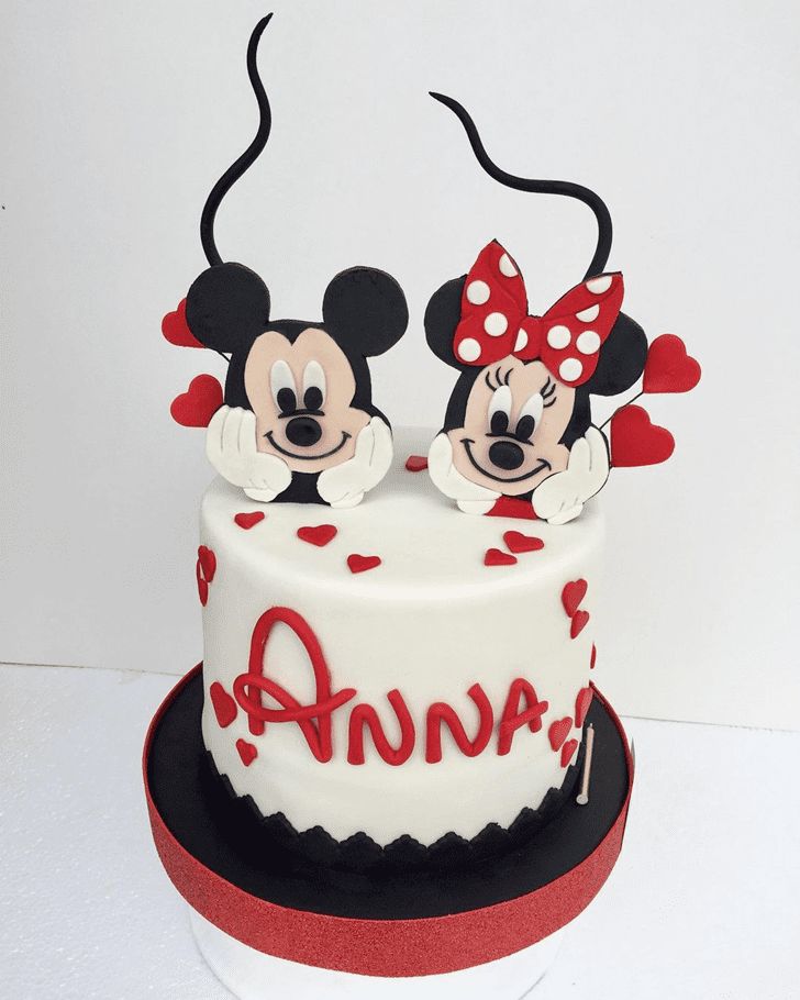 a mickey and minnie mouse cake with hearts on it