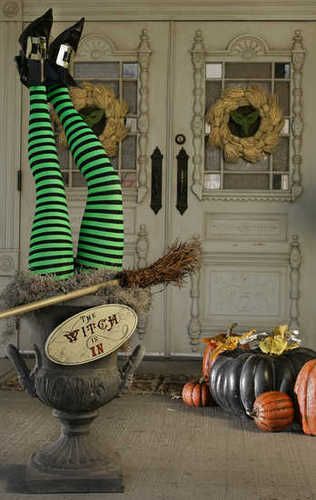 halloween decorations in front of a door with witch's brooms and pumpkins