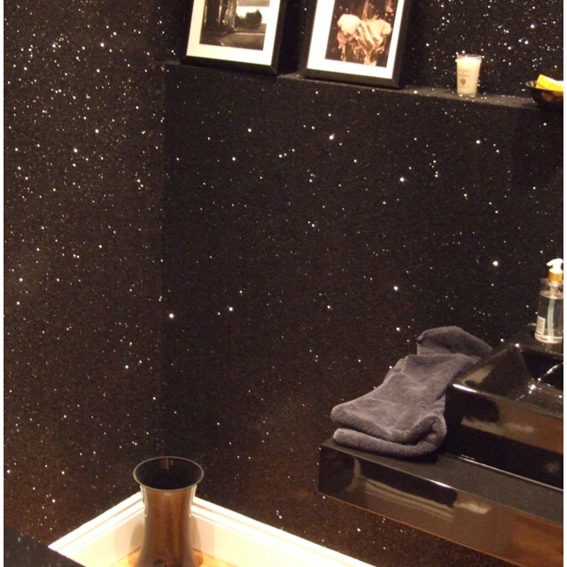 a bathroom with black walls and pictures on the wall, next to a mirror that says mix a gallon of glue with glitter then paint with it