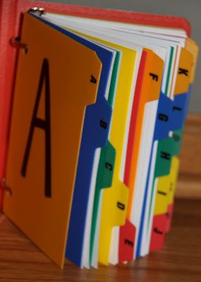 a set of colorful binders sitting on top of a wooden table