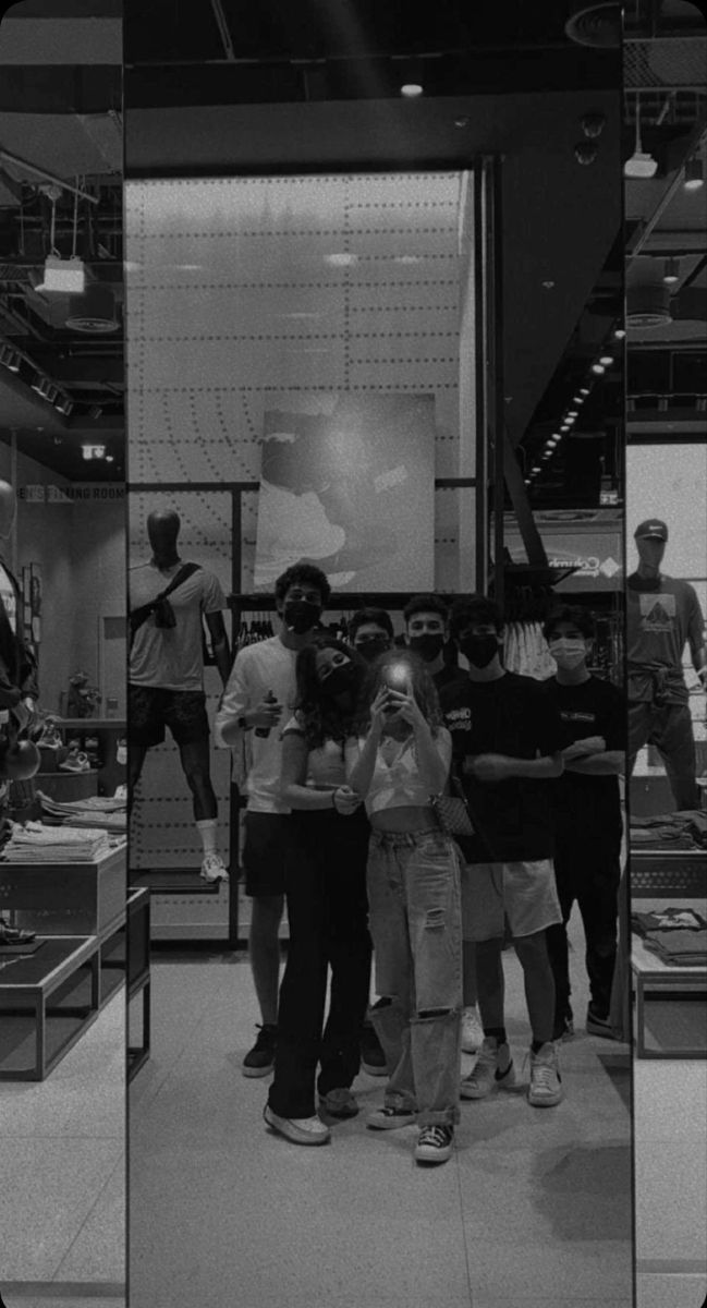 a group of people standing around each other in front of a display case filled with items