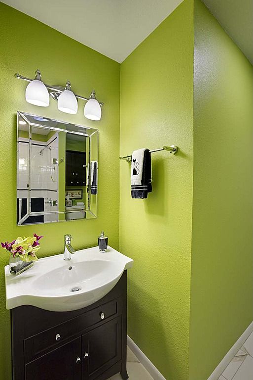 a bathroom with green walls and white tile flooring on the wall, along with a sink