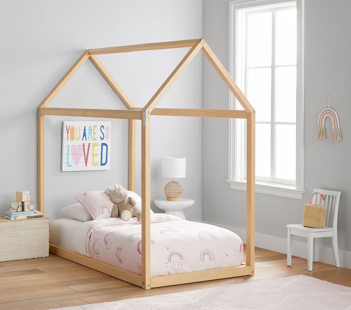 a child's bed with a wooden frame and canopy