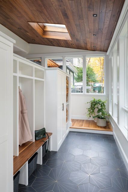 a room with a bench and some plants in the window sill next to it