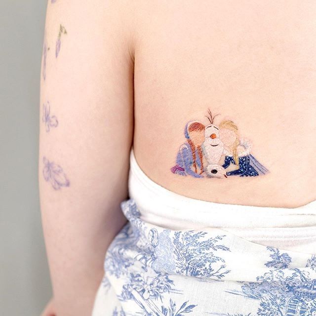 a woman with a tattoo on her stomach has two small bears hugging each other's shoulders