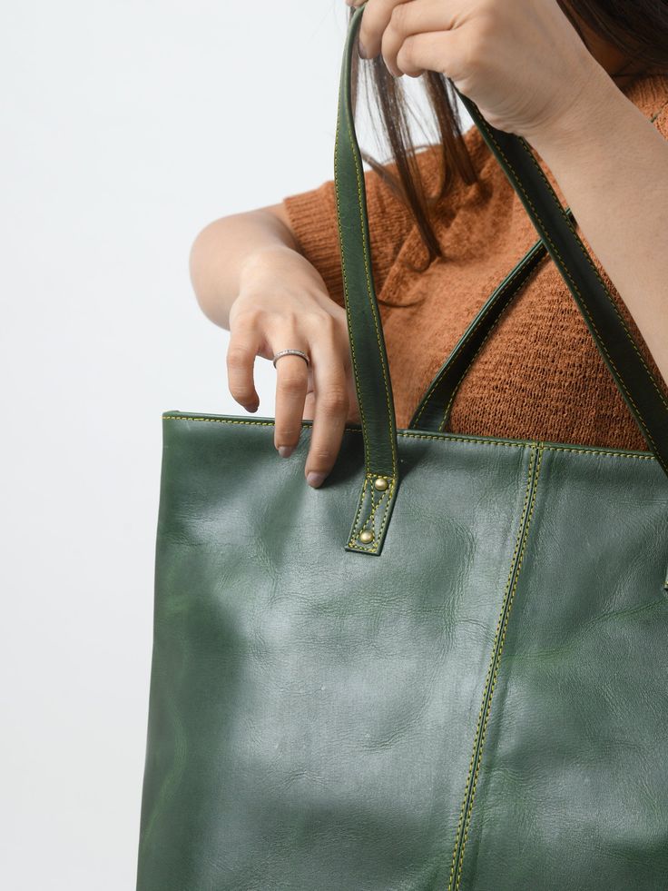 This Kim Tote is a stylish women's tote handbag that is a great choice for a trendy look. The simple, classic design in green makes it superior. The zipper gives easy access to the main compartment, which has one small zipper pocket inside the compartment for keeping your accessories and other small items securely and separately. This women's leather tote bag is made of the finest quality buffalo leather, accentuated with intricate detailing on the stitches. We offer excellent craftsmanship to e