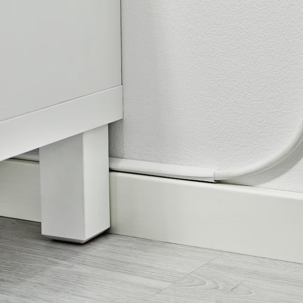 the corner of a white wall next to a door with a handle on it's side