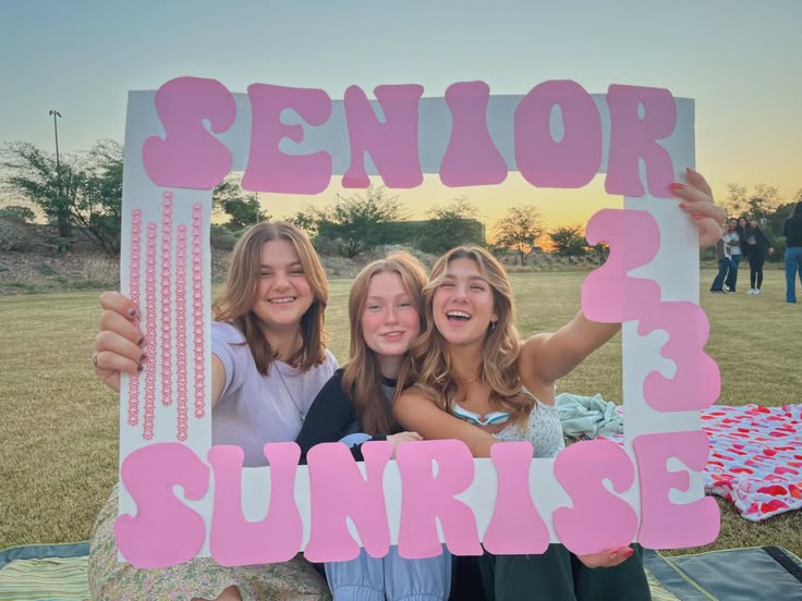 three girls holding up a sign that says senior 3, 3, and 3 sunrise