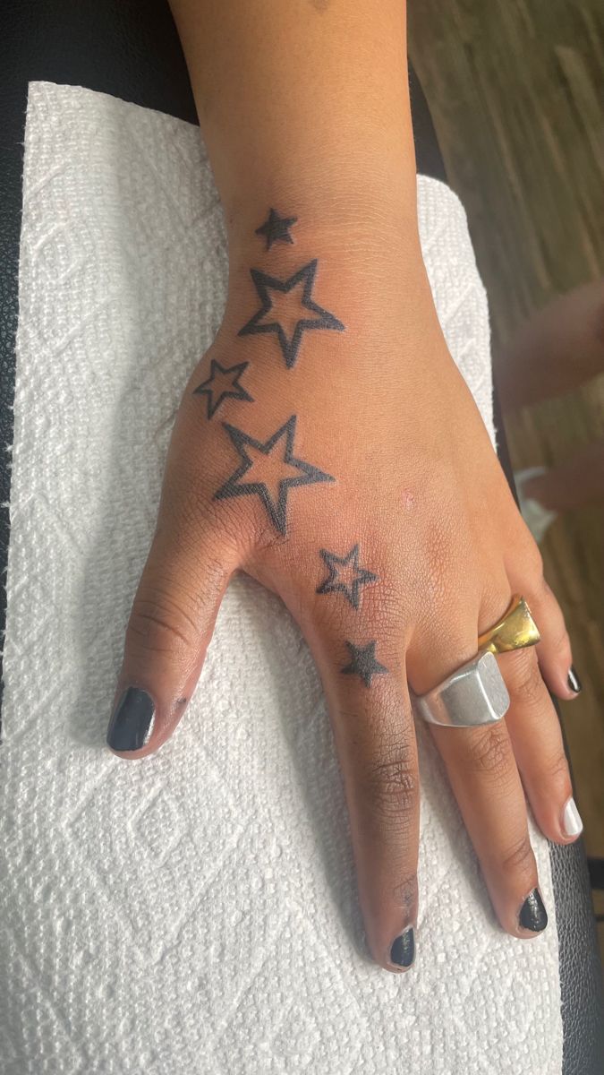 a woman's hand with stars tattooed on it