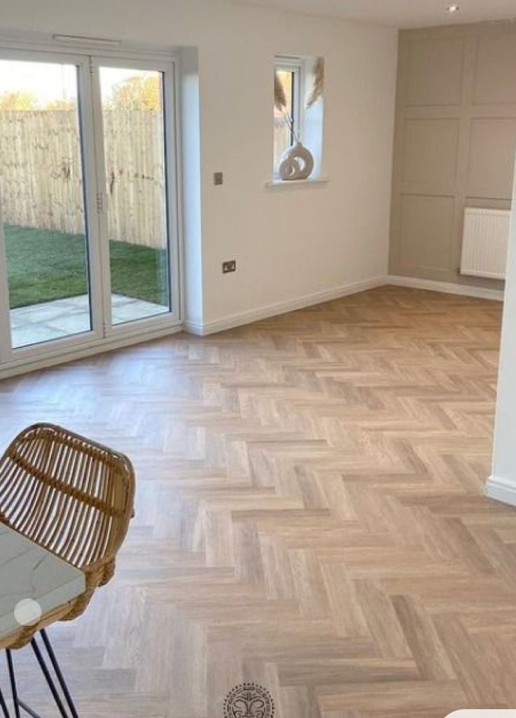 an empty living room with wooden floors and sliding glass doors