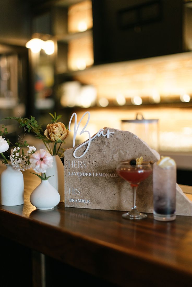 a table topped with vases filled with flowers next to a sign that says love