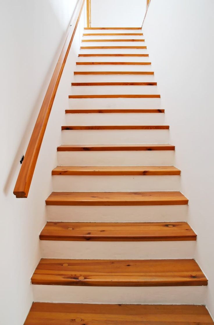 the stairs are made of wood and have white walls