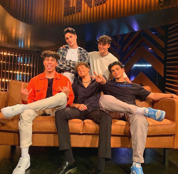 five young men sitting on a couch posing for the camera